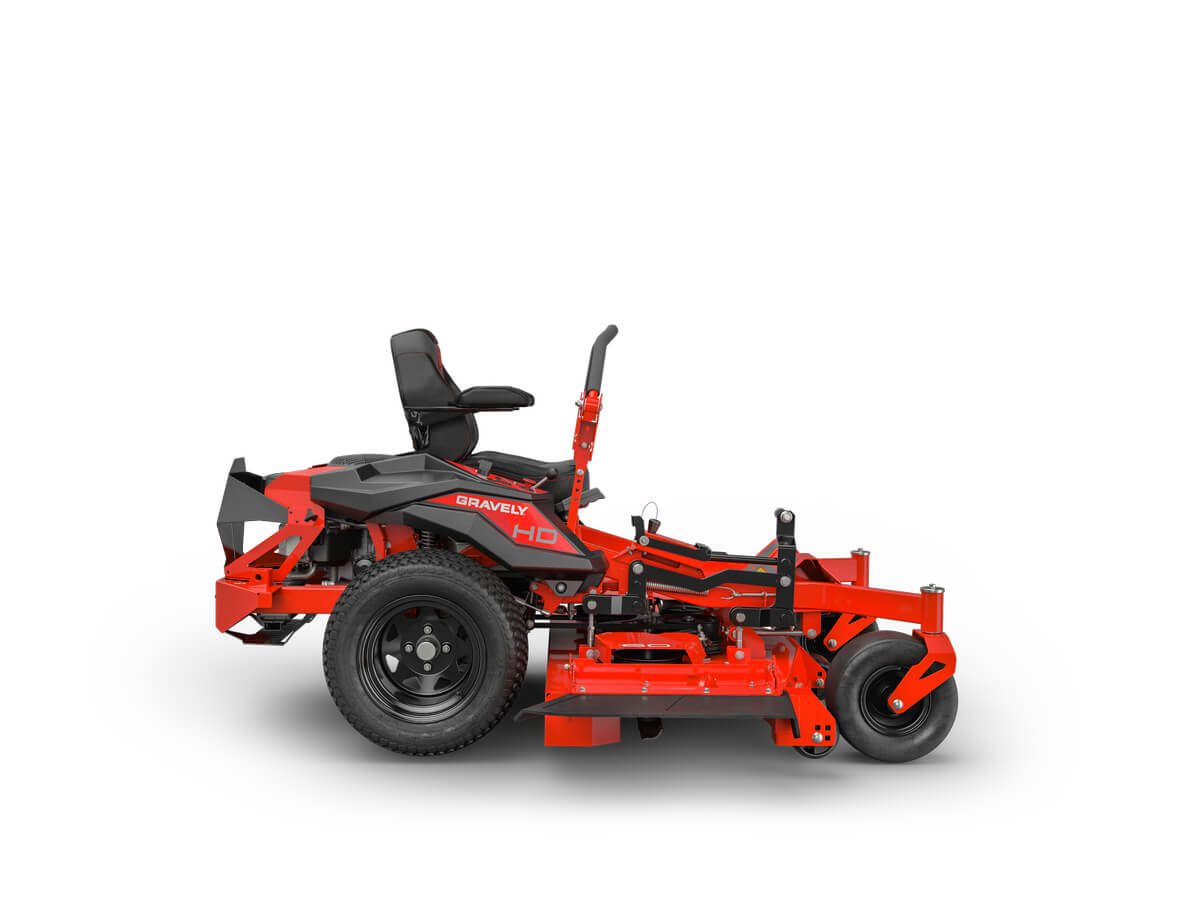 Red and black zero-turn lawn mower with a seat, large rear wheels, and a wide cutting deck, designed for efficient grass cutting.