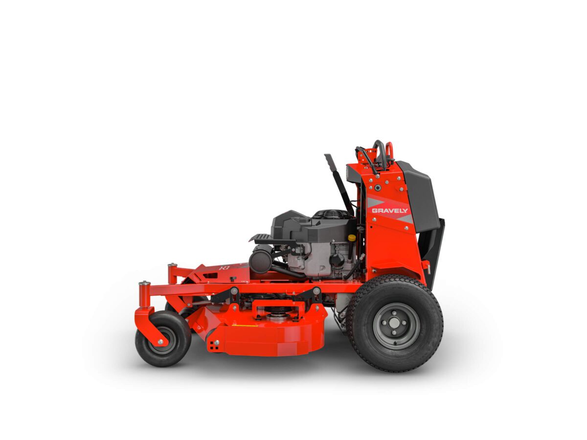 Red commercial lawn mower with a standing platform, featuring large rear wheels and a visible engine.