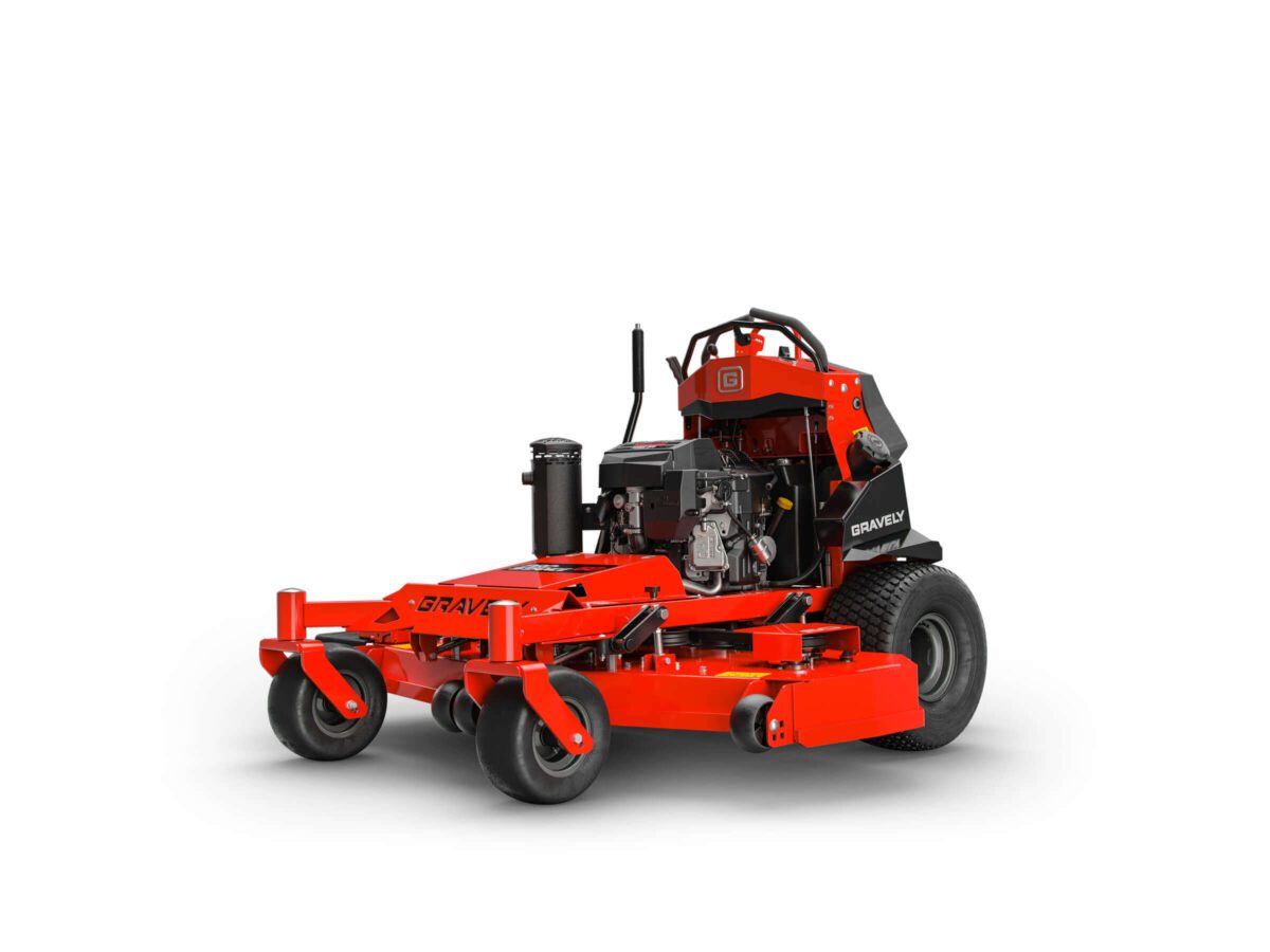 Red commercial lawnmower with large wheels, a cutting deck at the front, and a visible engine. The design includes a standing platform for the operator at the back.