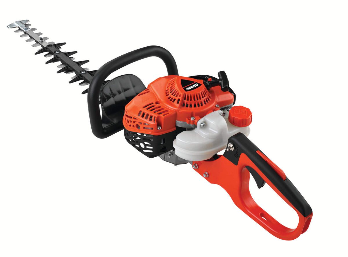 A red and black hedge trimmer with a long blade and a robust handle. The trimmer features a visible engine and control elements.