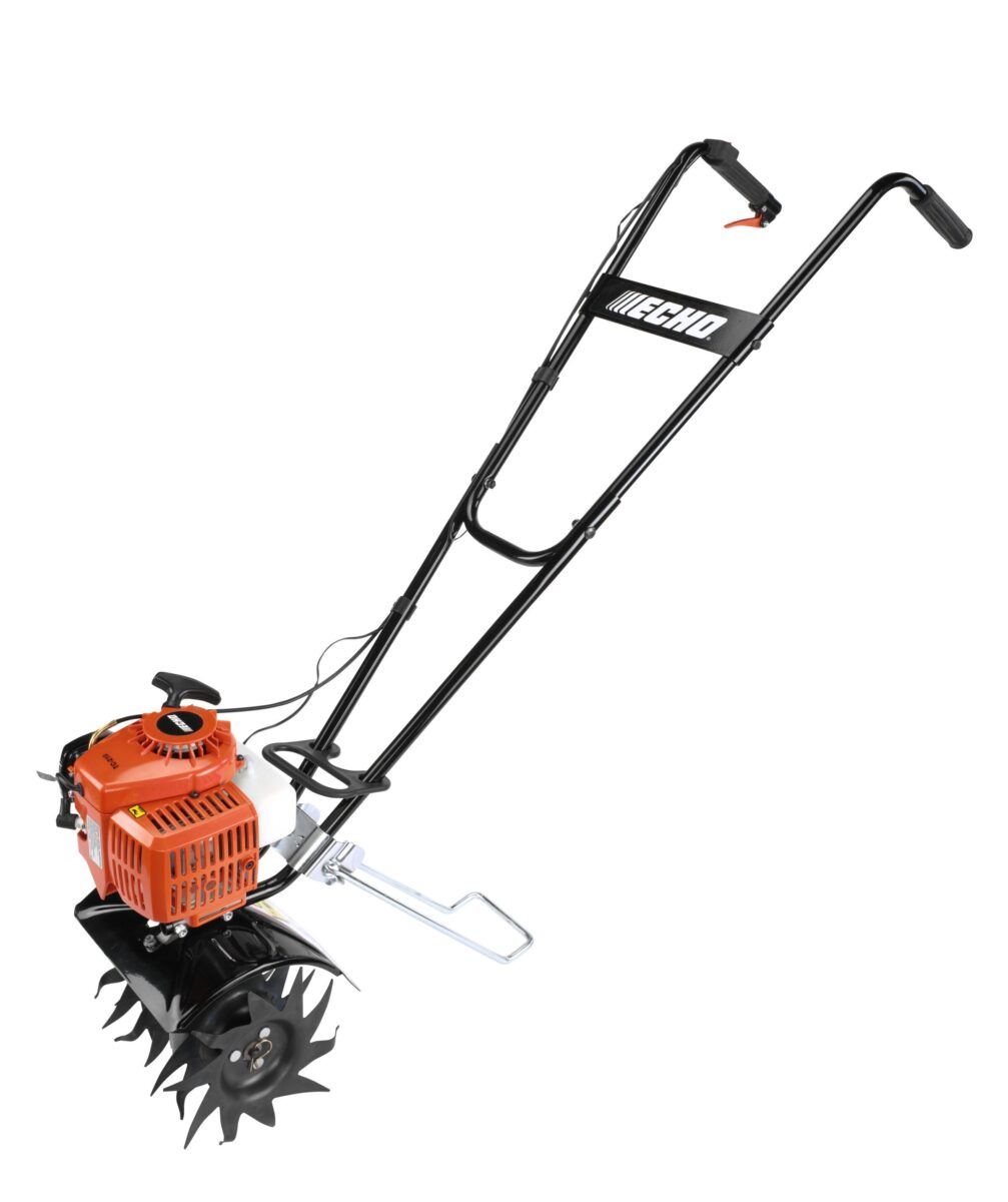 A garden tiller with a black metal frame and orange engine, featuring sharp blades for soil cultivation.