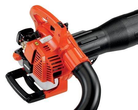 Close-up of an orange leaf blower with a black handle and nozzle, showcasing the engine casing and control elements.