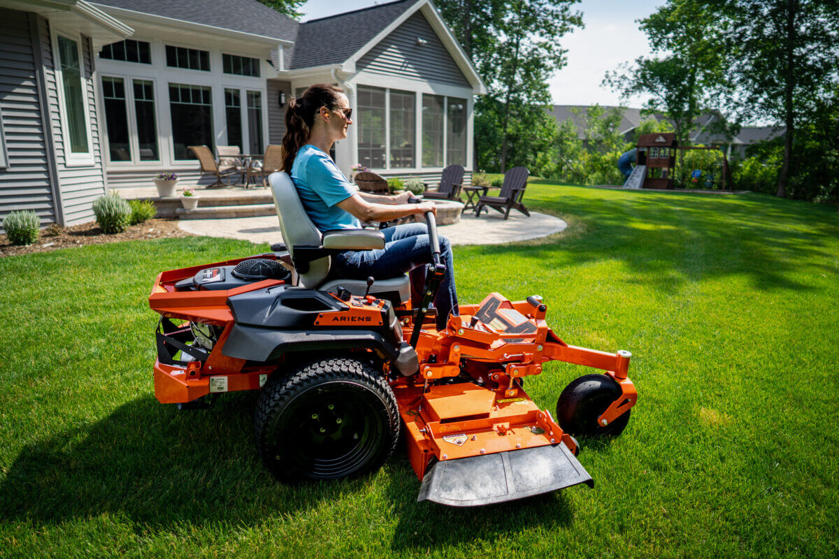 women riding the apex mower